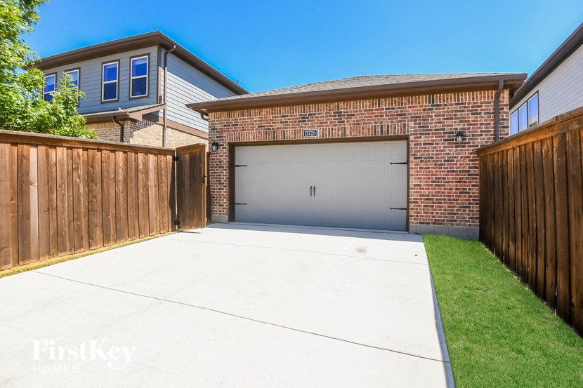 a driveway with a garage door in front of a house