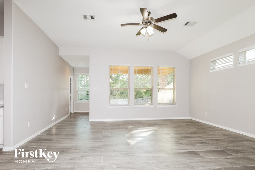 a clean empty living room with a ceiling fan