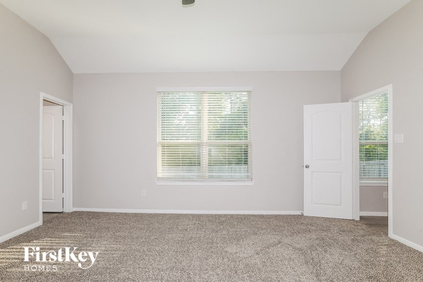 a room with carpet and a window and a door