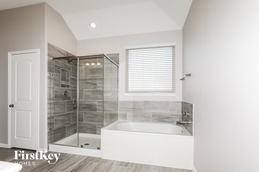 a bathroom with a tub and a shower and a door
