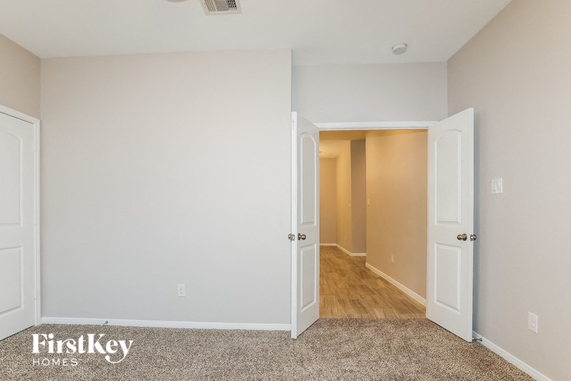 a bedroom with an open door and a hallway to a closet
