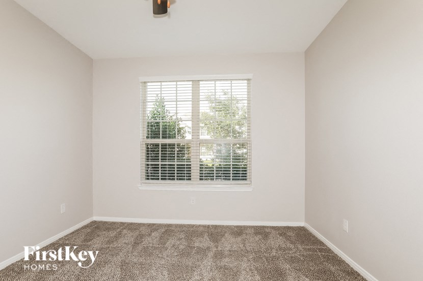an empty room with a window and carpet