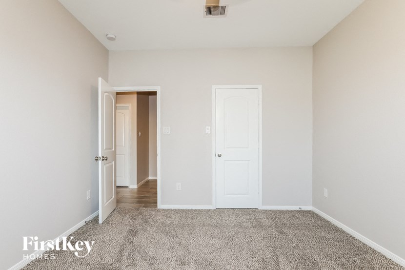 a bedroom with a carpeted floor and white doors