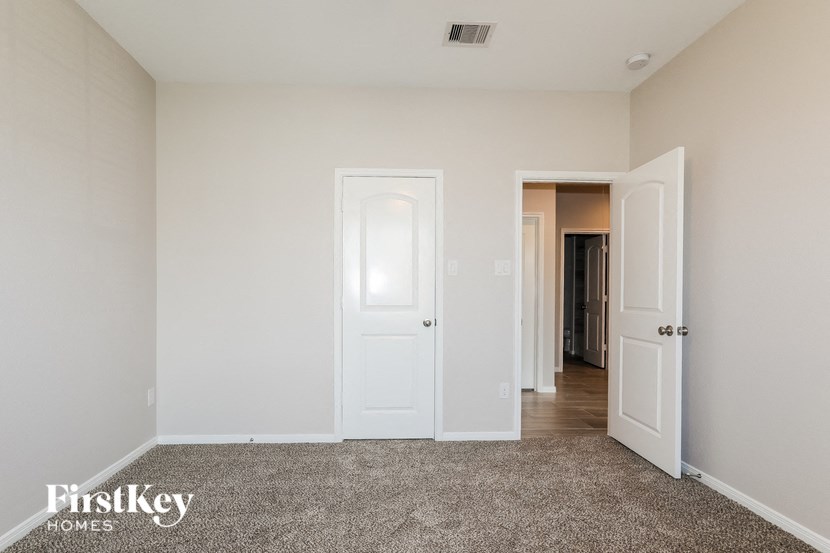a master bedroom with a carpeted floor and white doors