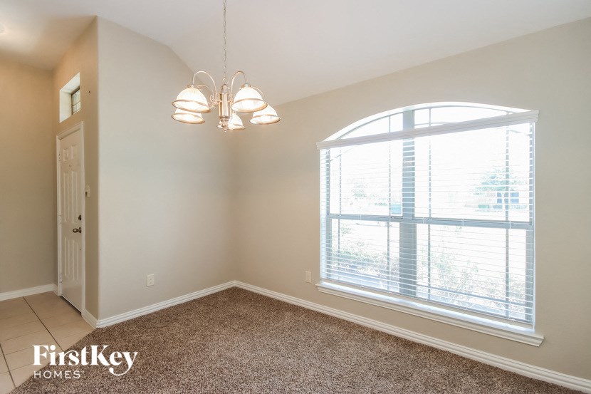 a dining room with a large window and a chandelier