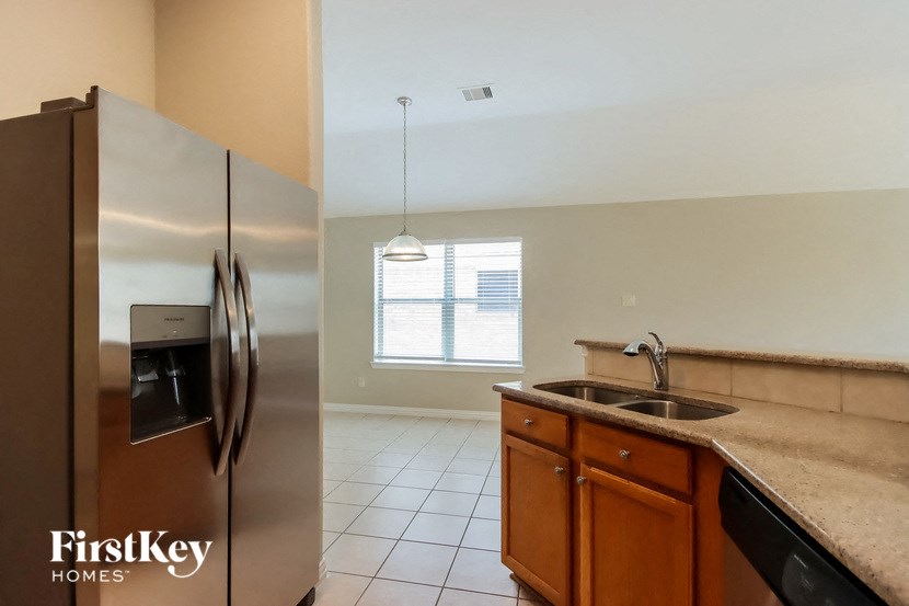 a kitchen with a stainless steel refrigerator and a sink