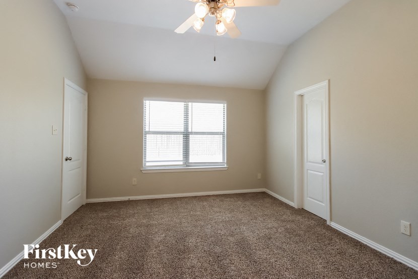 a bedroom with a window and a carpeted floor