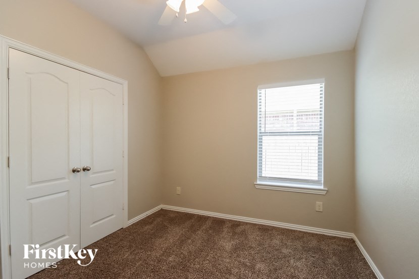 the bedroom of a home with a white door and a window