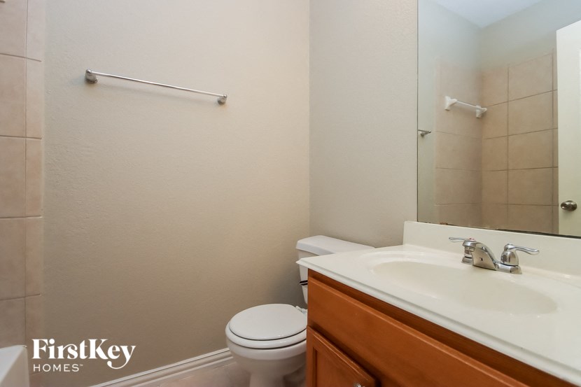 a bathroom with a sink toilet and a mirror