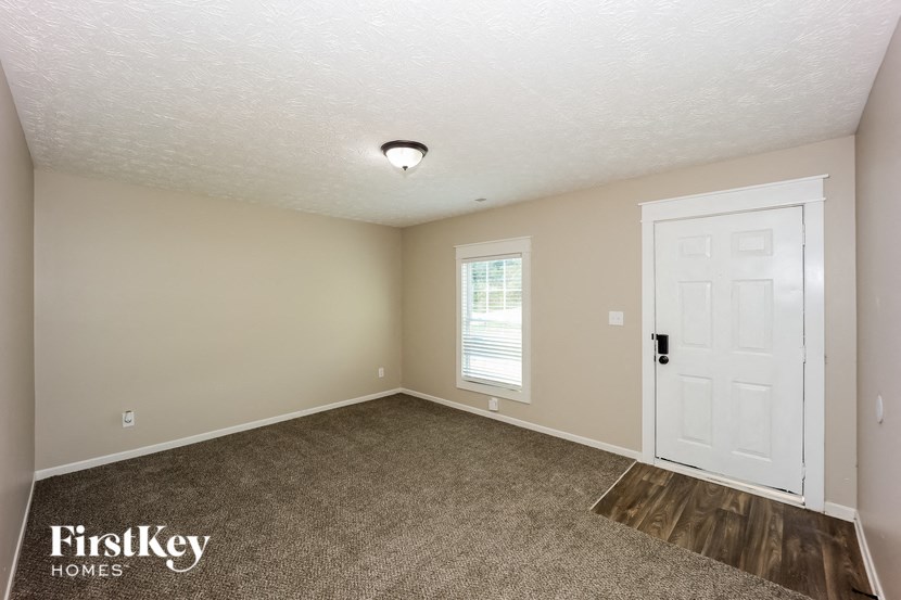a bedroom with a white door and a carpeted floor