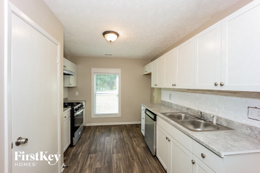 a kitchen with white cabinets and a sink and a window
