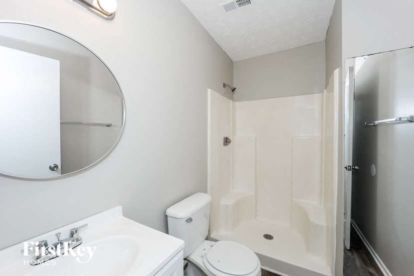 a bathroom with a shower toilet and sink and a mirror