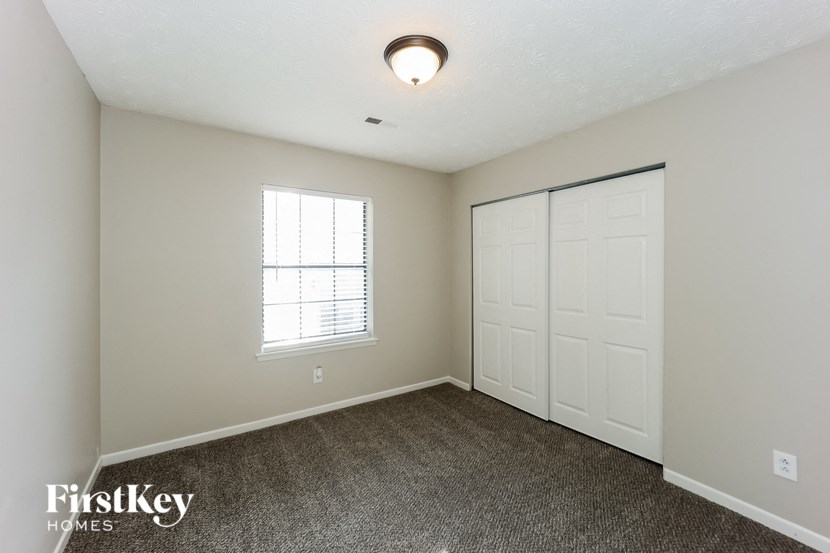 a bedroom with a closet and a door and a window