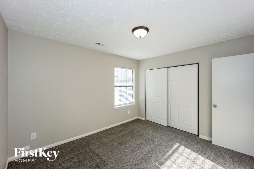the living room of an empty house with a door and a window