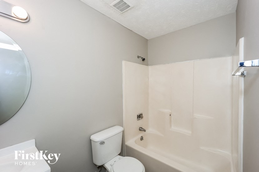 a bathroom with a toilet and a tub and a sink