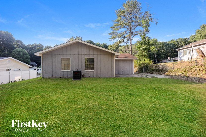 a backyard with a house and a grassy yard