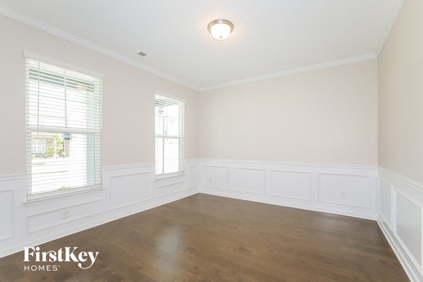 an empty room with wood floors and white walls