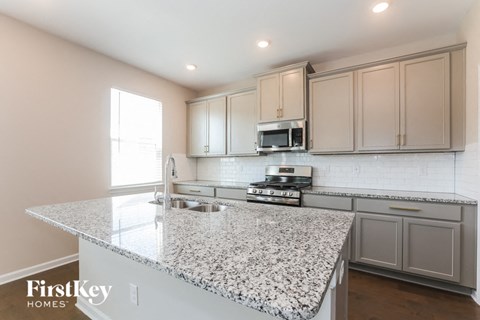 a kitchen with white cabinets and granite counter tops
