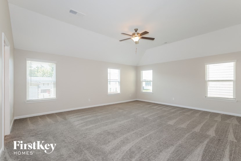 an empty living room with a ceiling fan