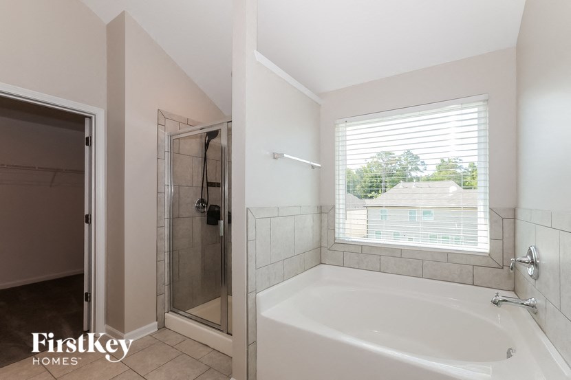 a bathroom with a tub and a shower and a window