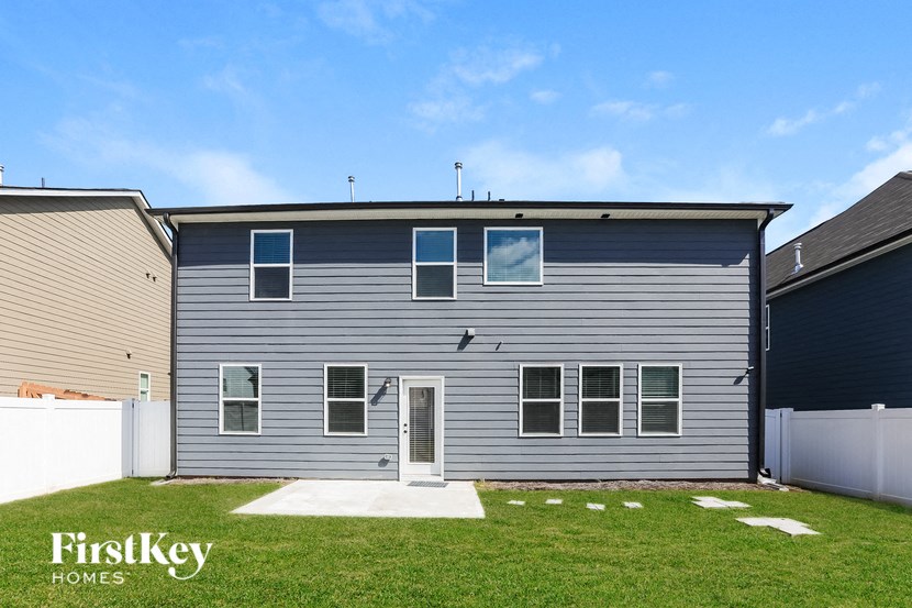 a blue house with white siding and a lawn