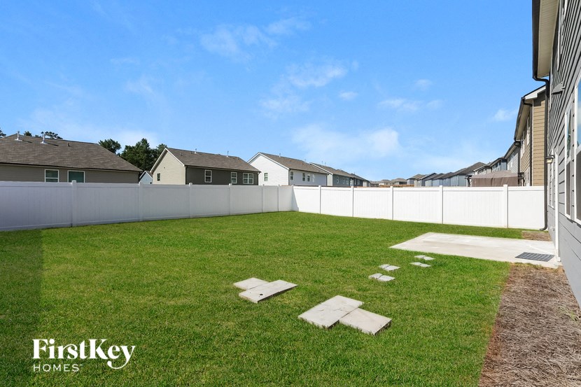 the back yard of a house with stepping stones in the grass