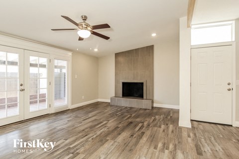 a living room with a fireplace and a ceiling fan