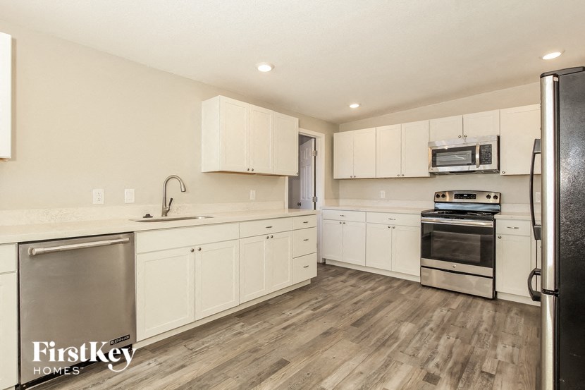 a kitchen with white cabinets and stainless steel appliances