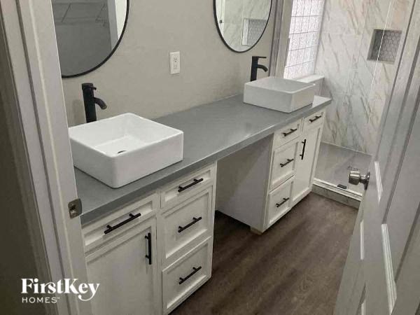 a bathroom with two sinks and two mirrors