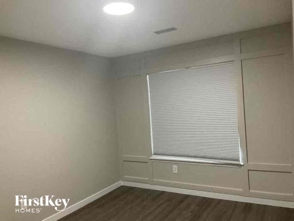 an empty room with a window and a wooden floor