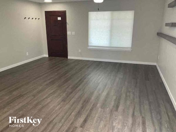 an empty living room with a wooden floor