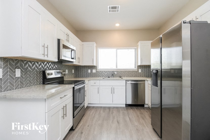 a kitchen with stainless steel appliances and white cabinets