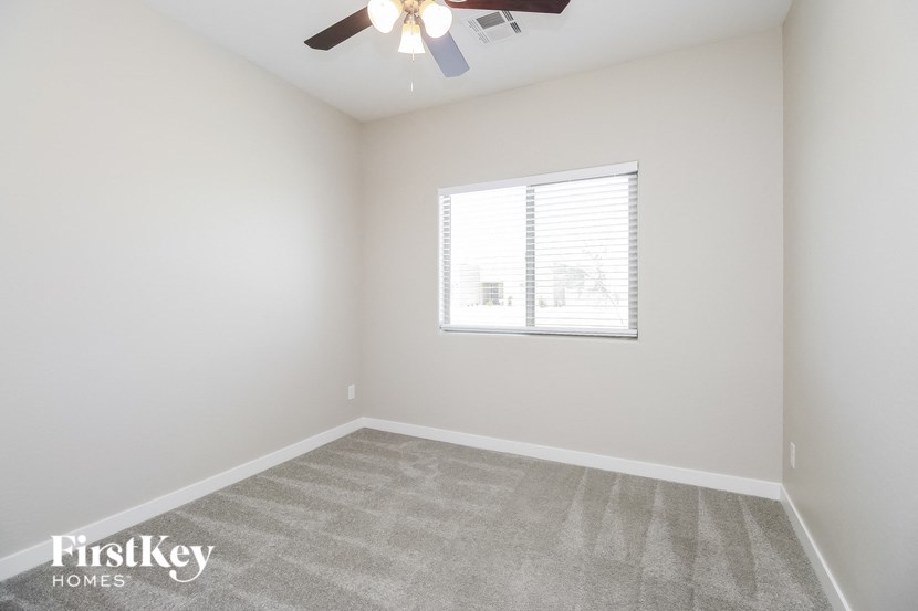 an empty room with a window and a ceiling fan