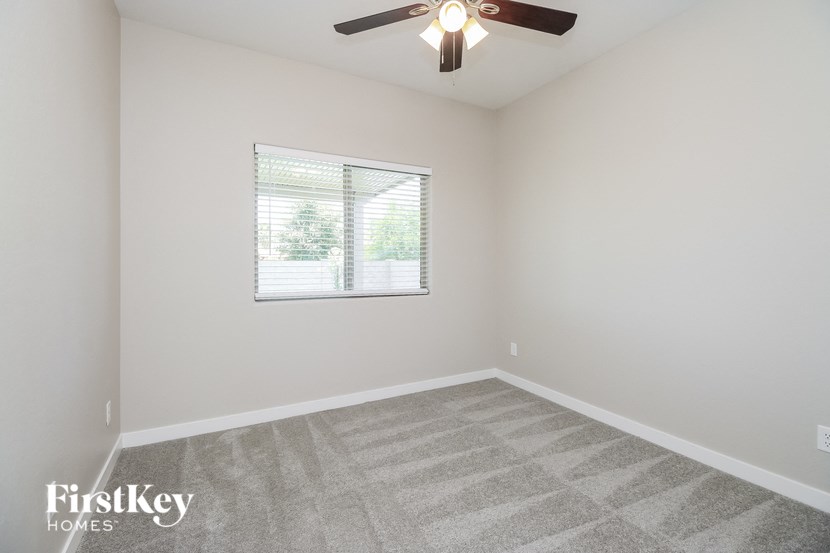 an empty room with a window and a ceiling fan