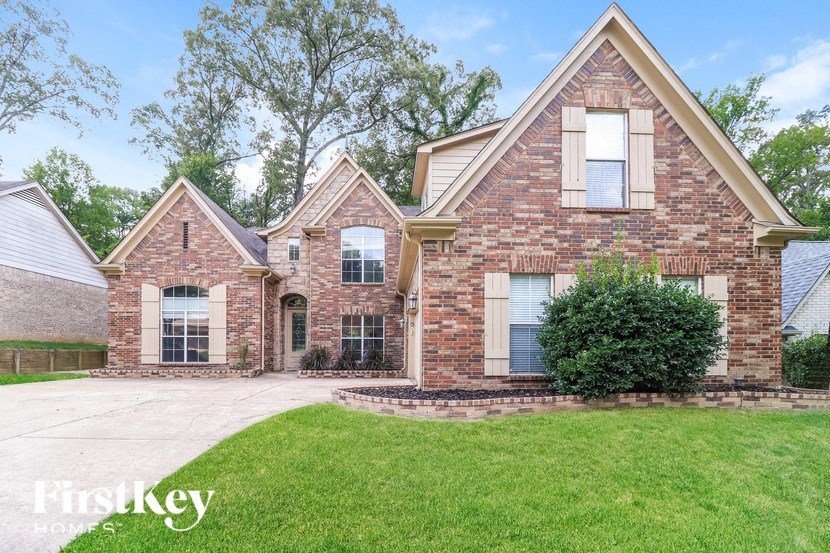 A brick house with a green lawn in front.
