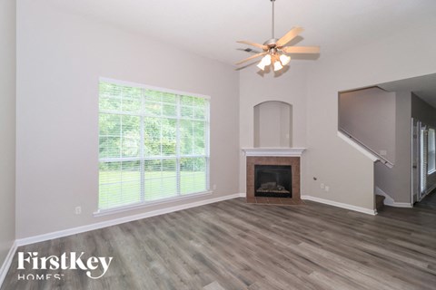 A room with a fireplace and a ceiling fan.
