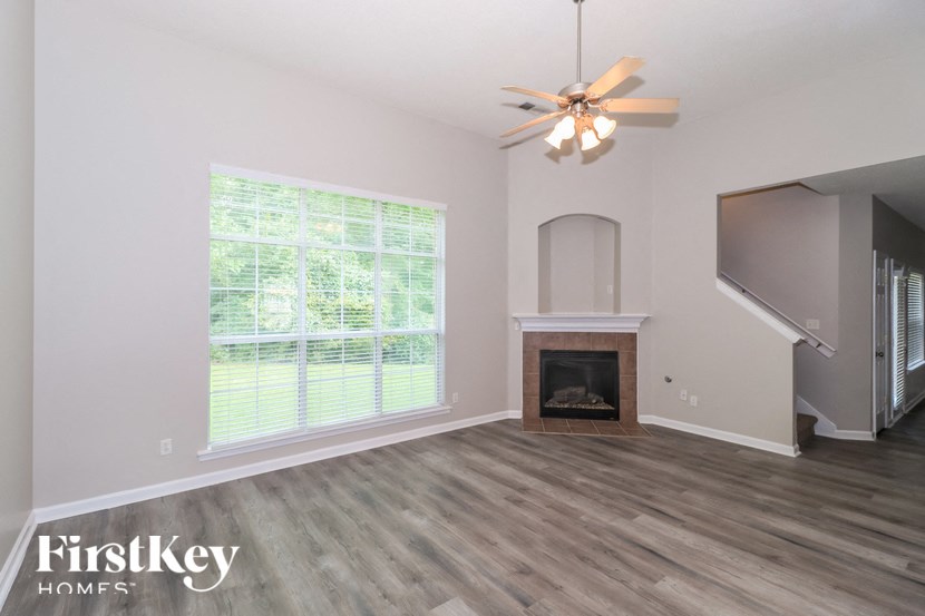 A room with a fireplace and a ceiling fan.