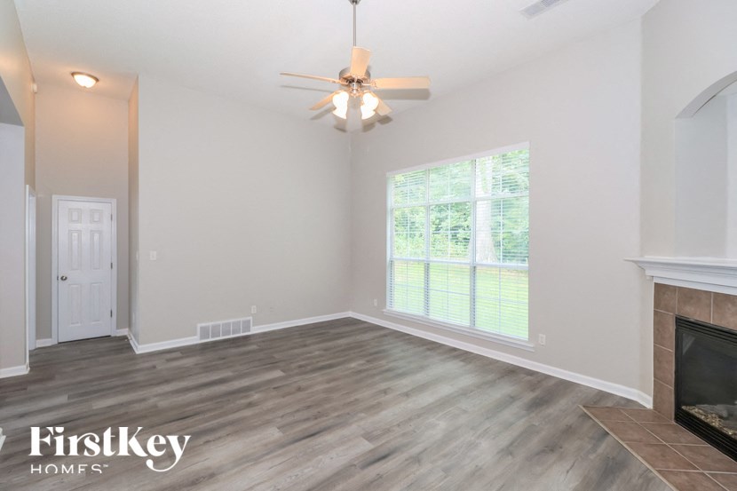 A room with a fireplace and a ceiling fan.