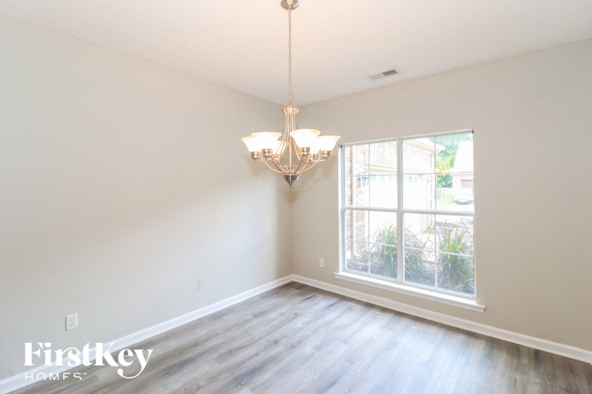 A room with a chandelier and a window.