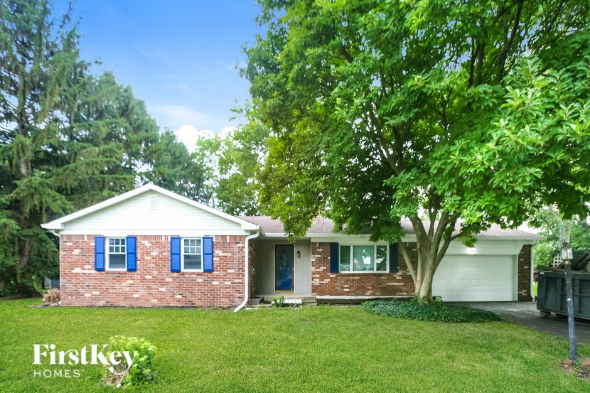 A brick house with a tree in front of it.