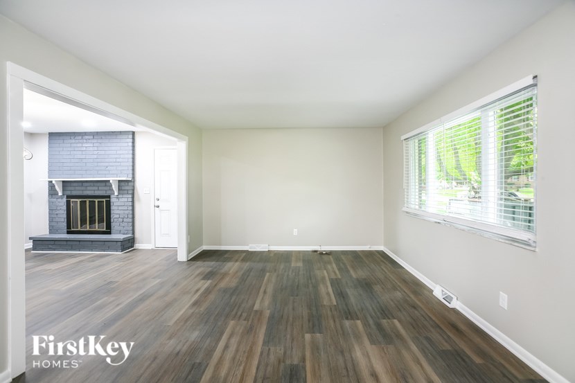 A room with wooden flooring and a fireplace.