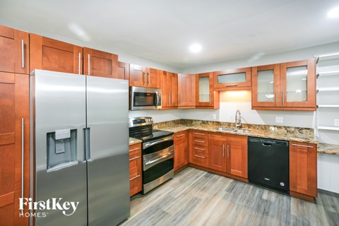 A kitchen with wooden cabinets and a stainless steel refrigerator.