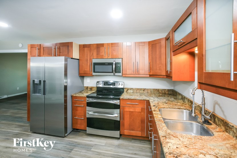 A kitchen with wooden cabinets and a stainless steel refrigerator.