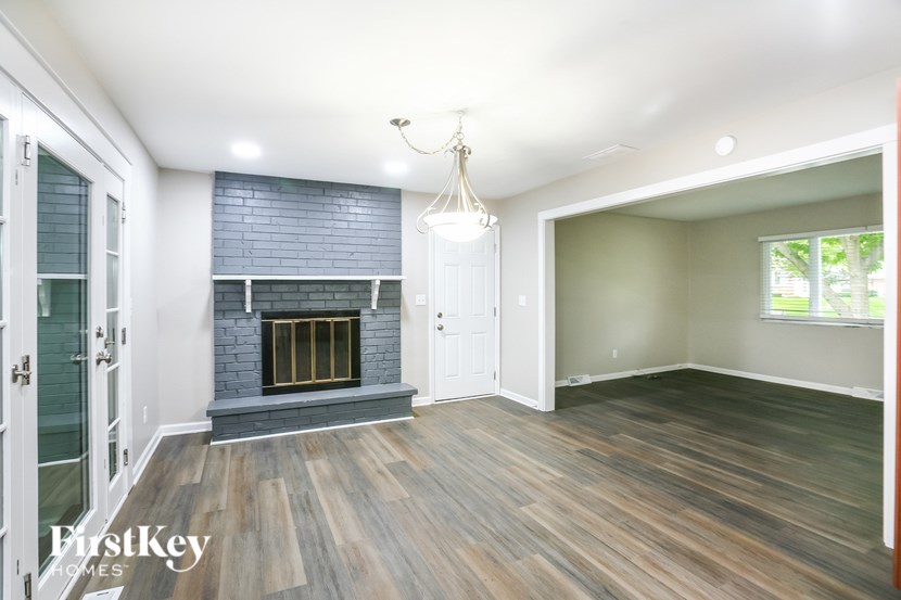 A room with a fireplace and wood flooring.