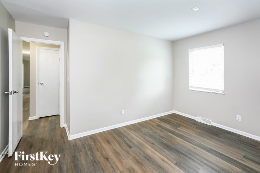 A room with wooden flooring and a window.