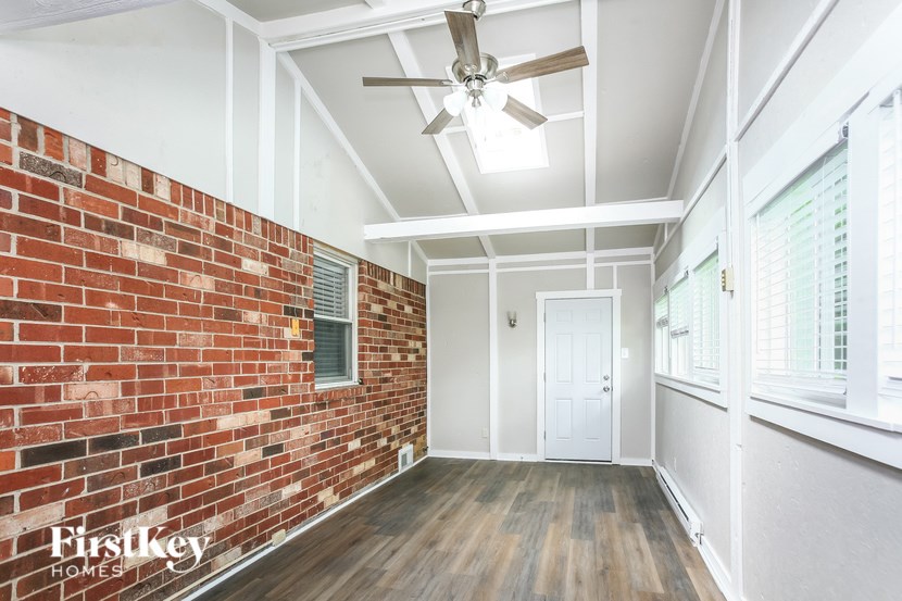 A room with a brick wall and wooden flooring.