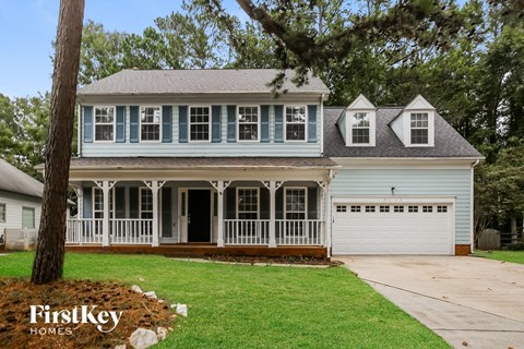 a white house with a white front porch and a white garage door