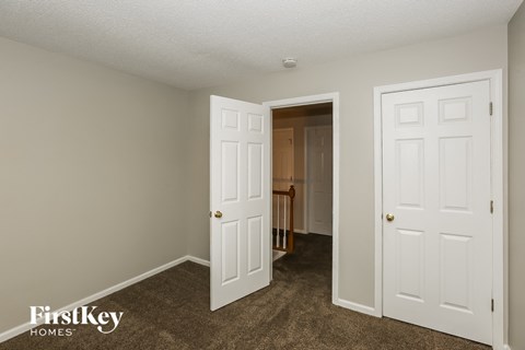 a bedroom with two closets and a door to a hallway