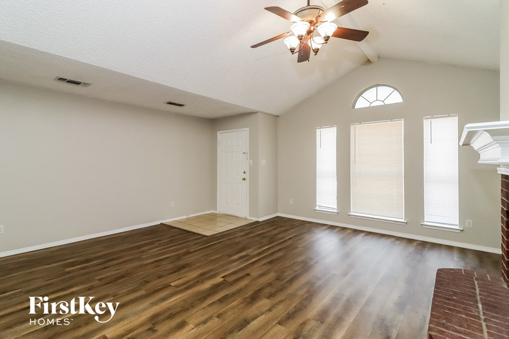 the living room with hardwood floors and a ceiling fan