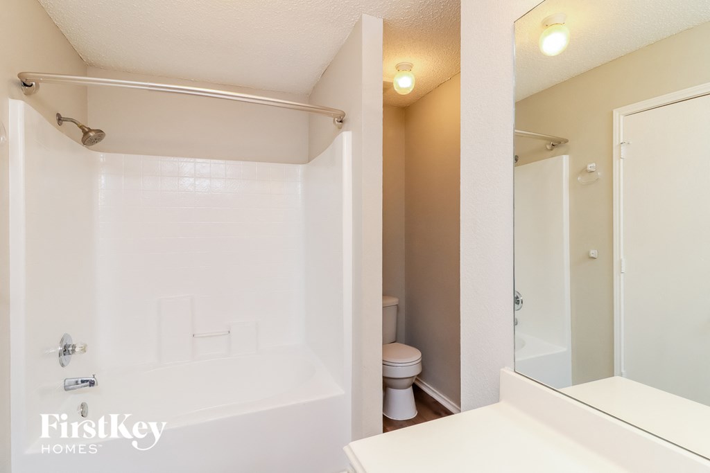a bathroom with a tub and a shower and a sink